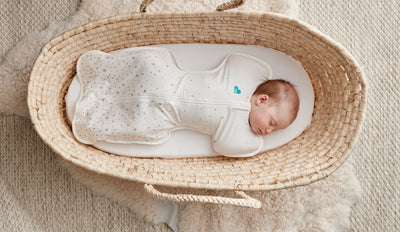 Baby in a moses basket wearing a Love to Dream swaddle
