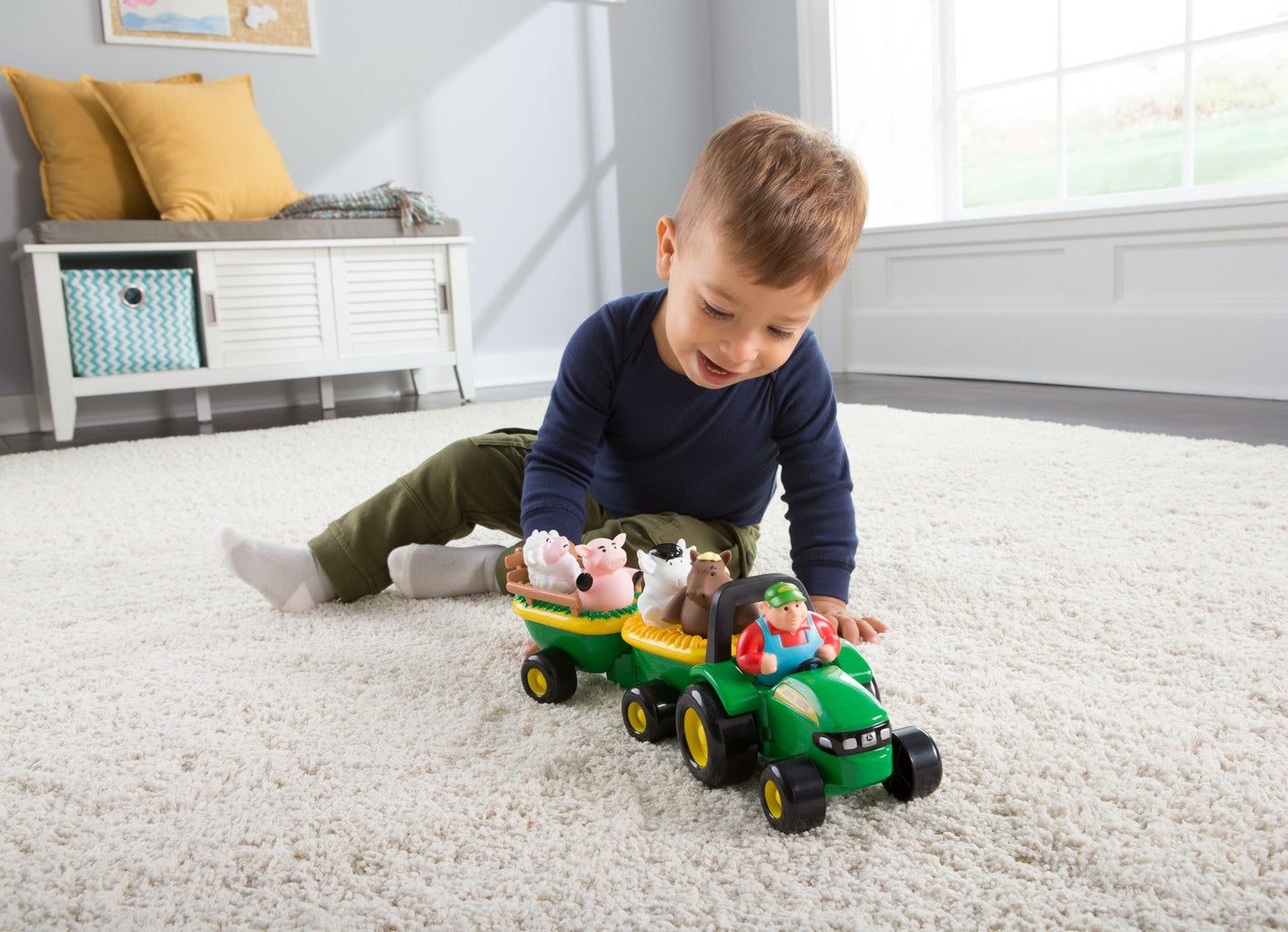 Boy playing with John Deere toy on carpet floor