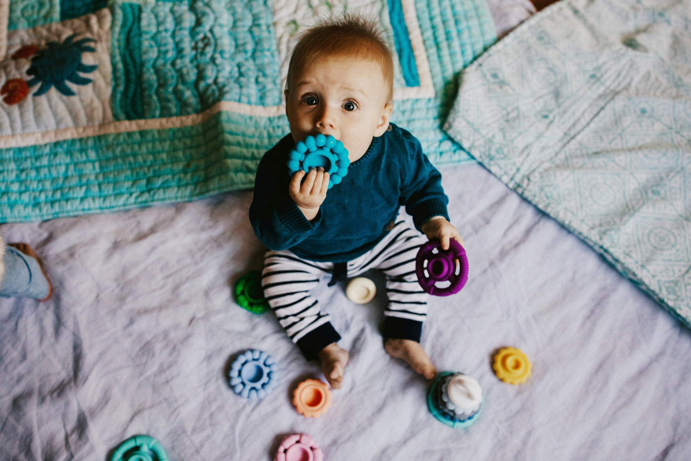 Baby on a mat with teether in mouth
