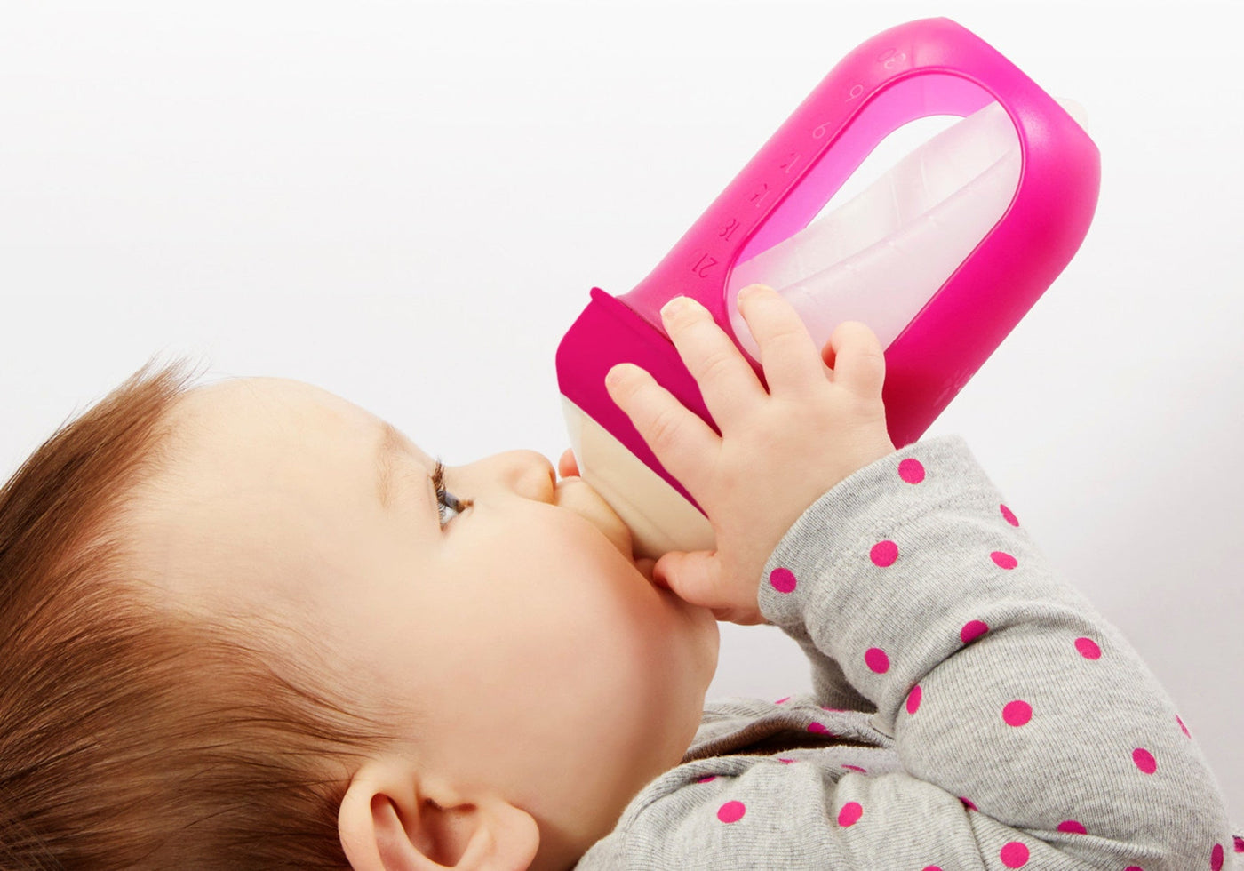 Baby drinking from a pink baby bottle