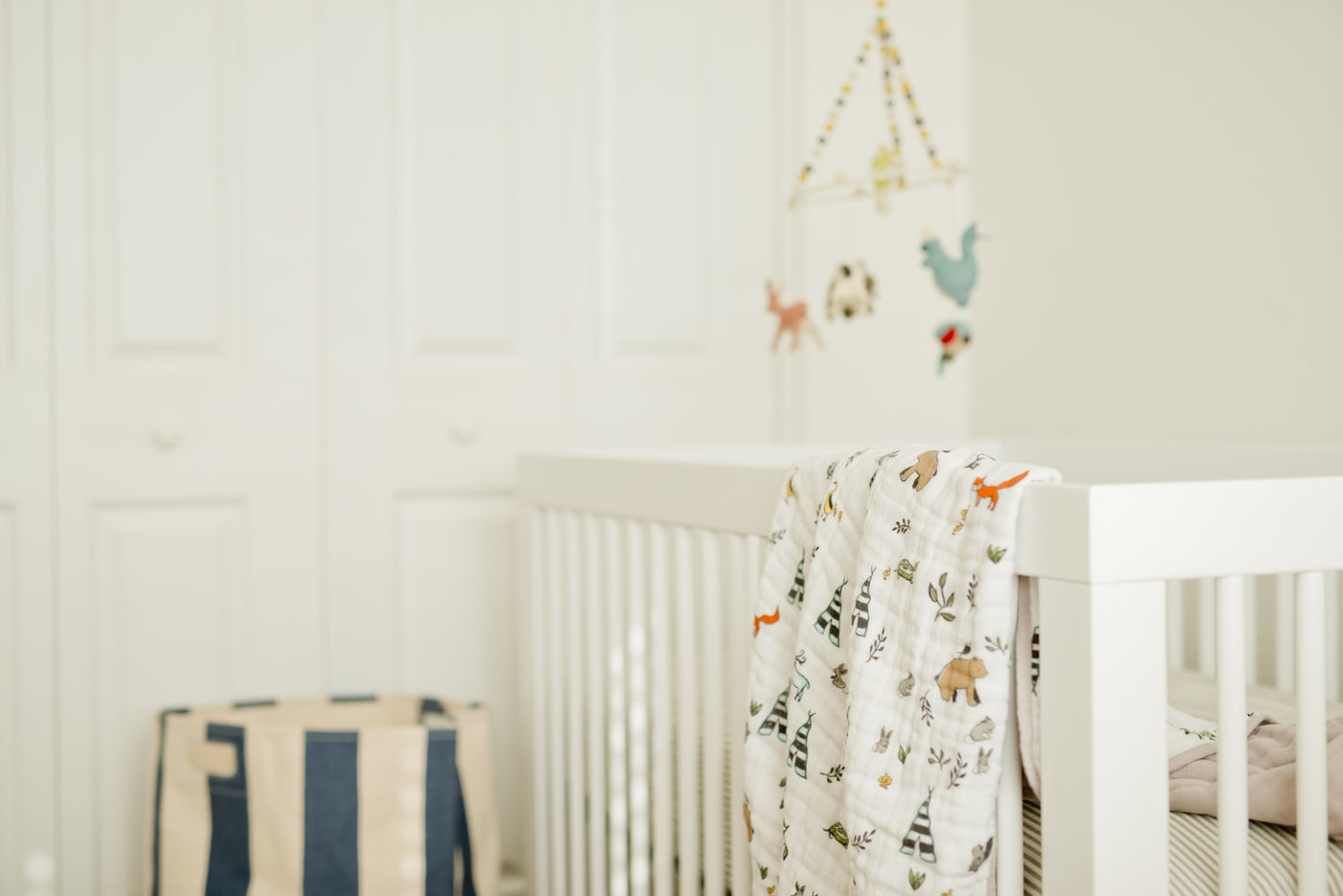 Baby's quilt draped over a cot in a nursery