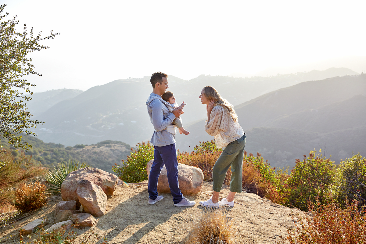 Parents and baby out in nature in the Ergobaby Omni Breeze.