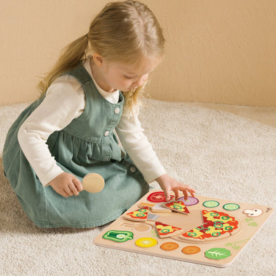 Child playing with a wooden pizza puzzle on a carpeted floor.