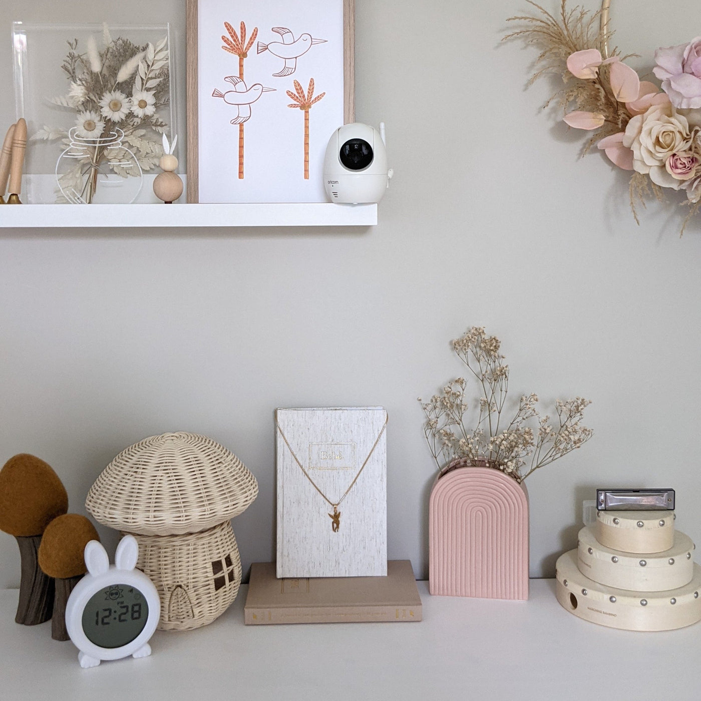 Decorative items on a shelf including a mushroom-shaped lamp, a clock, and a vase with dried flowers.